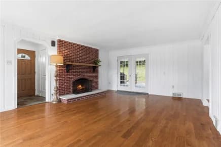 Living room with a brick gas fireplace and French doors