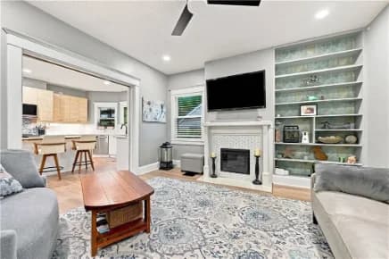 Living room with a tiled fireplace and built-in shelves
